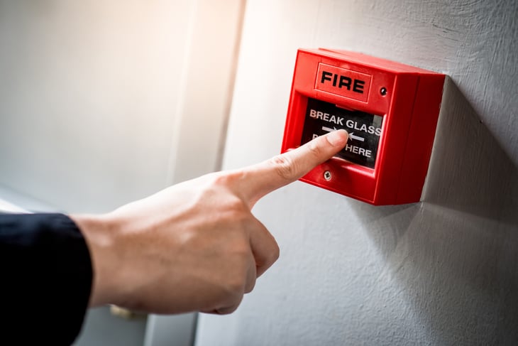Hand presses fire alarm
