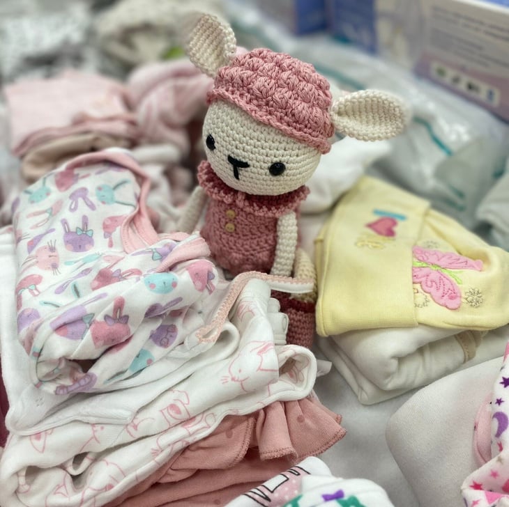 Folded babies clothes and a toy rabbit