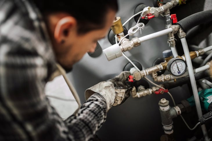 Stock image of a guy fixing a boiler