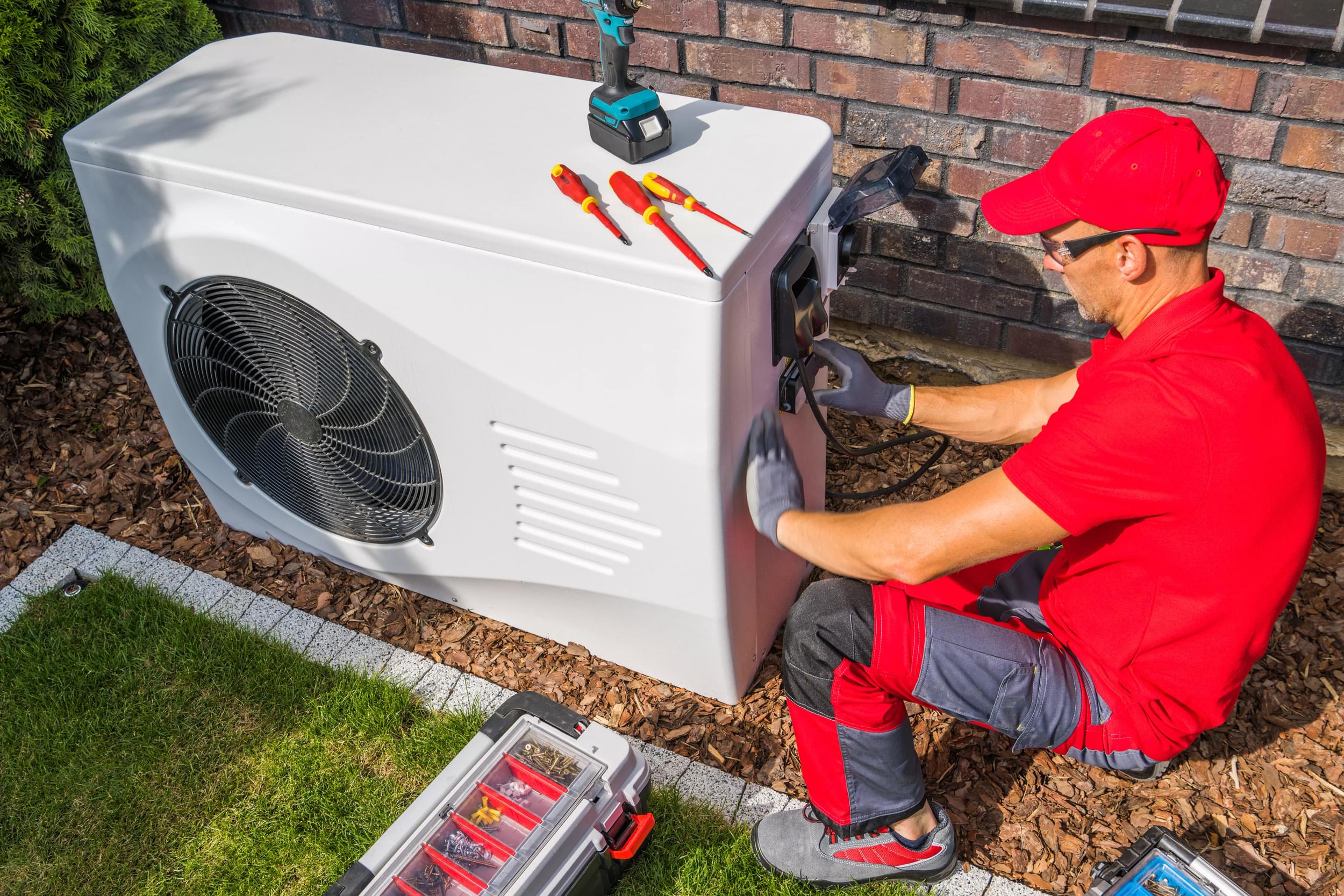 Guy fixing an air source heat pump